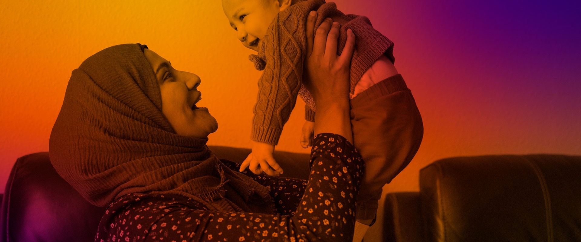 Women holding baby aloft in her cosy home