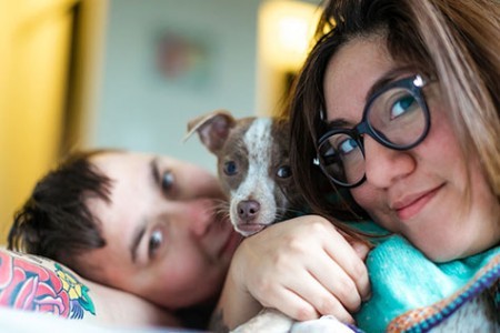 Women snuggling with child and puppy