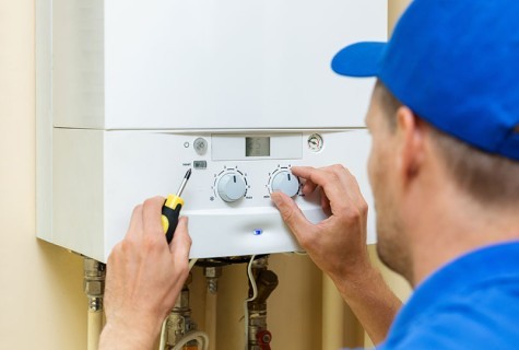 Heating Engineer Adjusting A Boiler